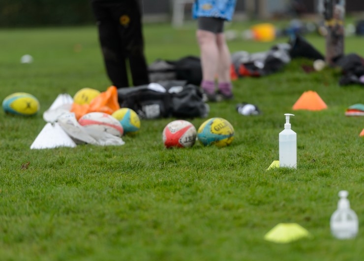 Rugby balls, hand gel and cones on the field.