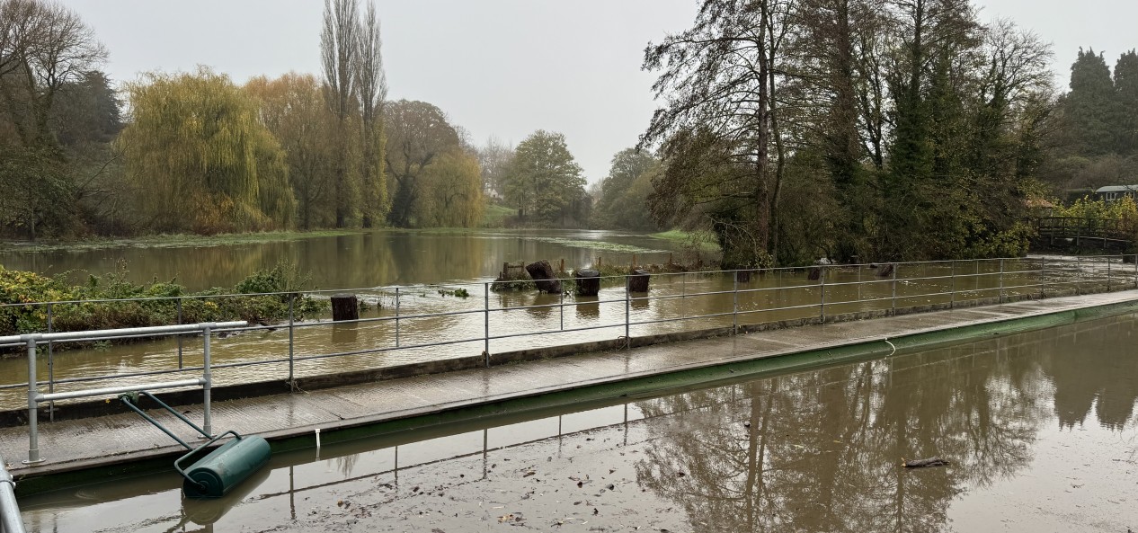 A bowling green flooded by an adjacent river